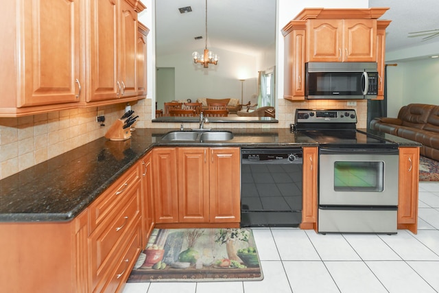 kitchen featuring stainless steel appliances, lofted ceiling, decorative backsplash, an inviting chandelier, and a sink