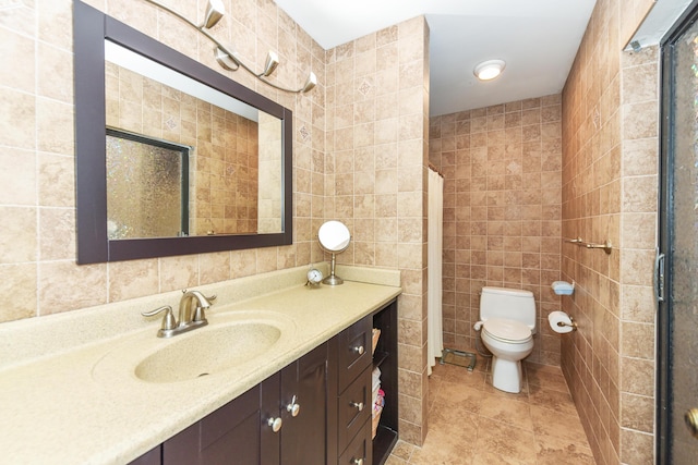 full bathroom featuring toilet, tile walls, vanity, and tile patterned floors