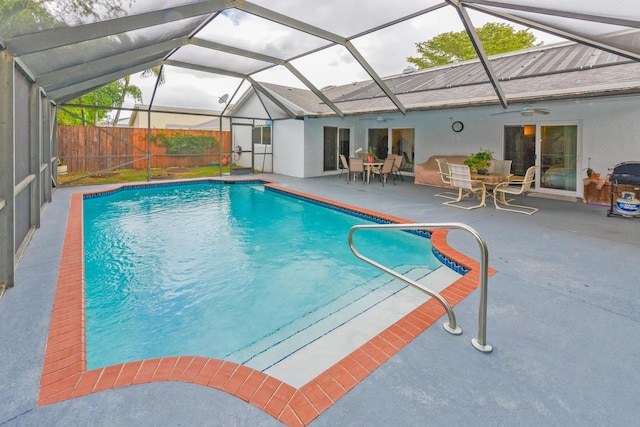 view of swimming pool with glass enclosure, fence, a fenced in pool, and a patio