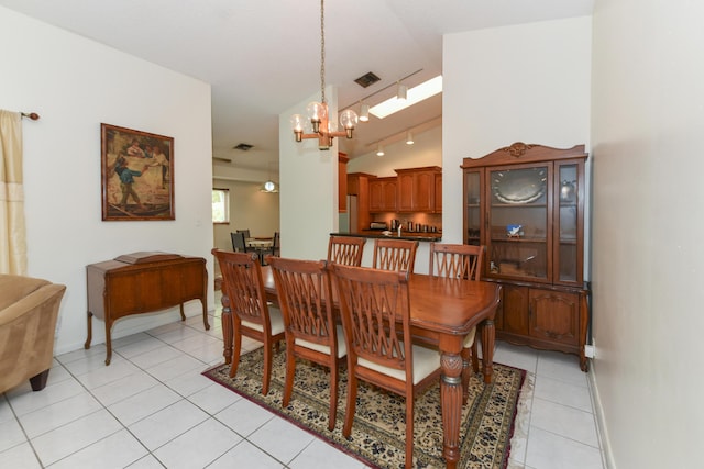 dining area with a notable chandelier, light tile patterned floors, visible vents, track lighting, and baseboards