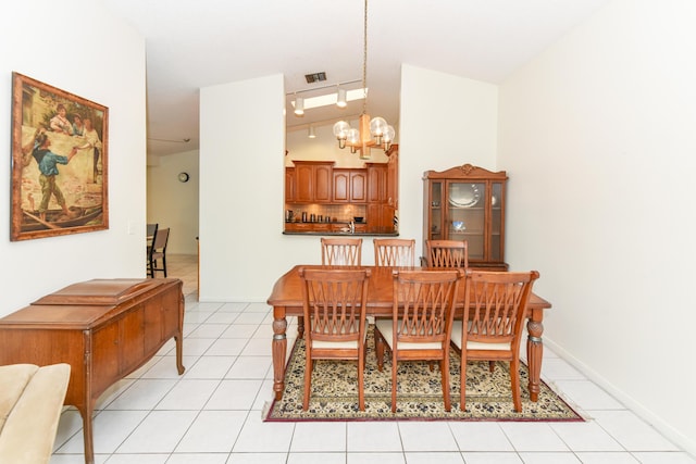 dining room featuring lofted ceiling, visible vents, rail lighting, an inviting chandelier, and light tile patterned flooring