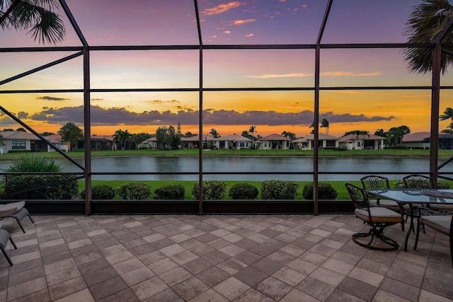 unfurnished sunroom with a water view and a residential view