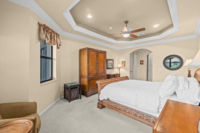 bedroom with visible vents, arched walkways, light colored carpet, a tray ceiling, and crown molding