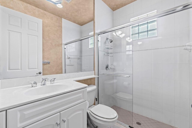 full bathroom featuring toilet, a stall shower, and vanity