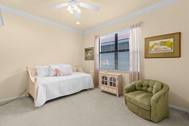 carpeted bedroom with a ceiling fan, crown molding, and baseboards