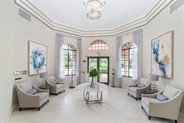 sitting room with a healthy amount of sunlight, visible vents, and a chandelier