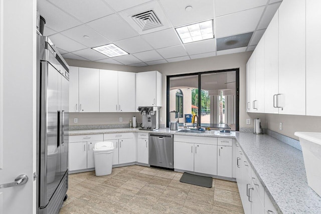 kitchen featuring stainless steel appliances, white cabinets, and visible vents