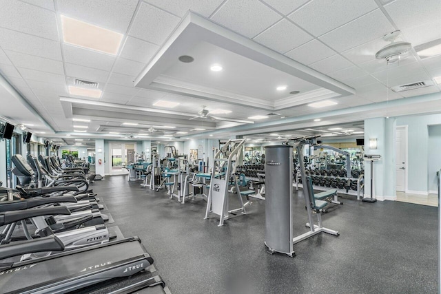 exercise room with ornamental molding, visible vents, and a drop ceiling