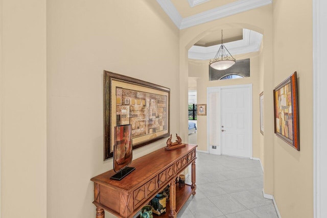 interior space with ornamental molding, arched walkways, light tile patterned flooring, and baseboards