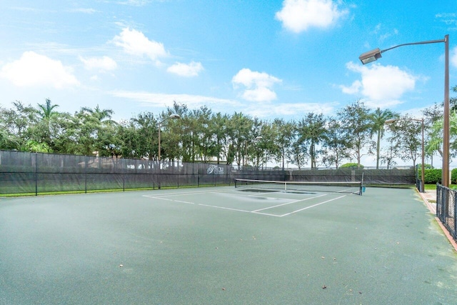 view of tennis court featuring fence