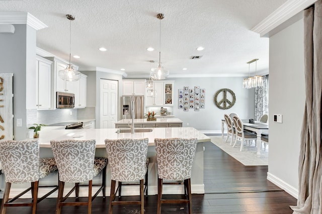 kitchen with a peninsula, appliances with stainless steel finishes, light countertops, and a kitchen breakfast bar