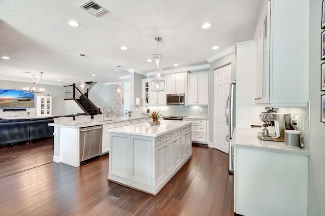 kitchen featuring a peninsula, dark wood-style flooring, white cabinetry, light countertops, and appliances with stainless steel finishes