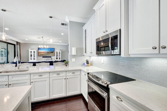 kitchen with stainless steel appliances, a sink, visible vents, and crown molding