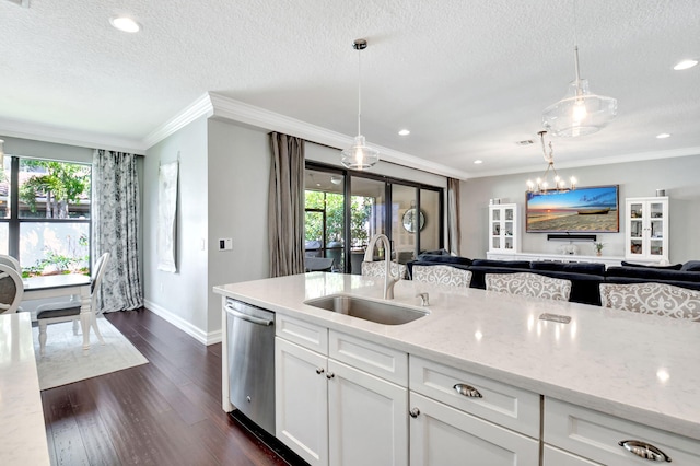 kitchen featuring light stone counters, a sink, open floor plan, dishwasher, and dark wood finished floors