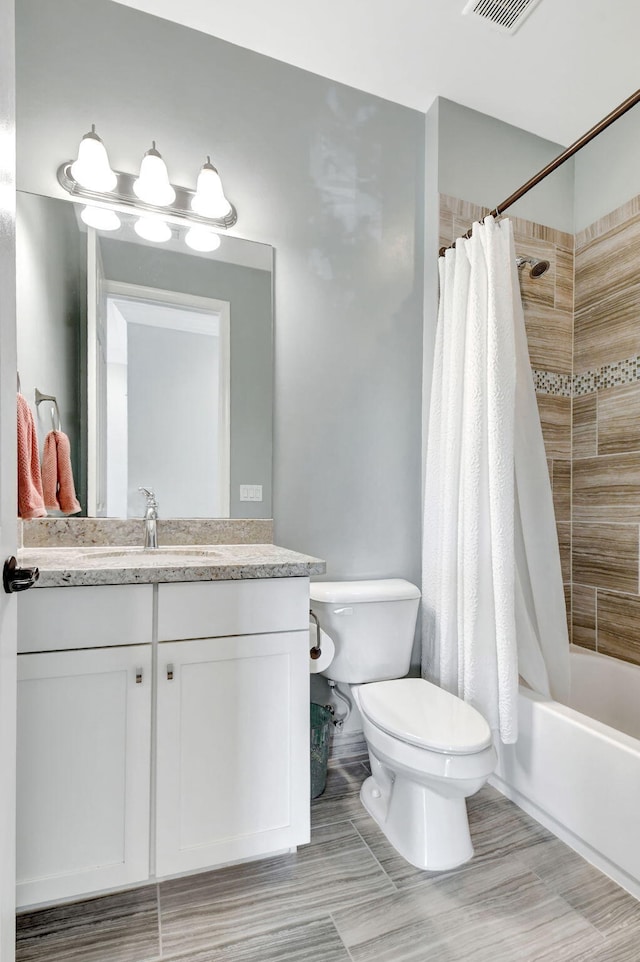 bathroom featuring toilet, visible vents, shower / bath combination with curtain, and vanity