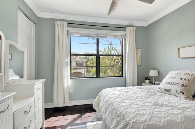 bedroom with dark wood-style floors, baseboards, and crown molding