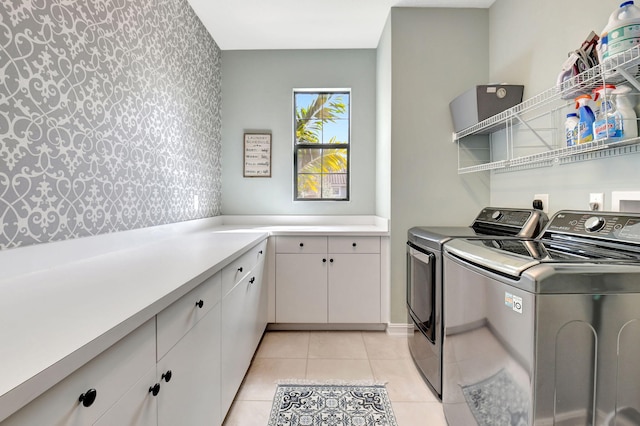 laundry room featuring light tile patterned flooring, washing machine and dryer, and cabinet space