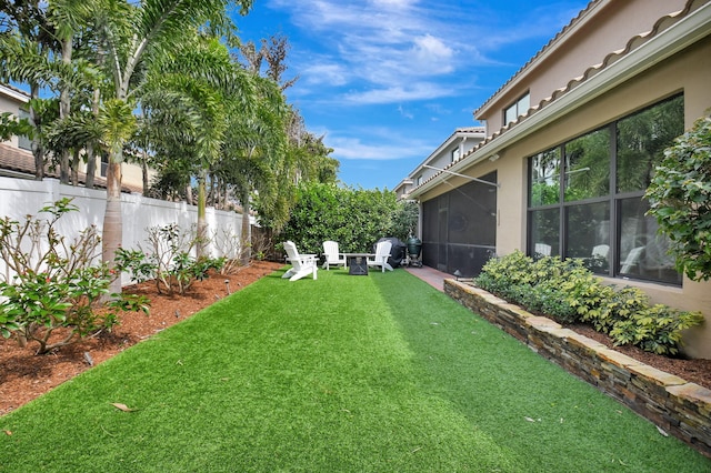 view of yard with a sunroom and fence