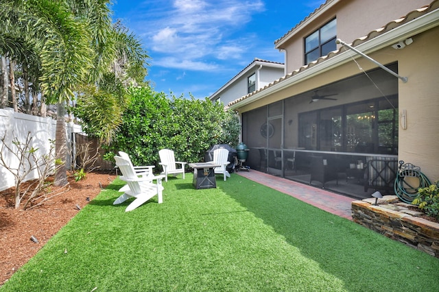 view of yard with a fire pit, a patio area, fence, and a sunroom