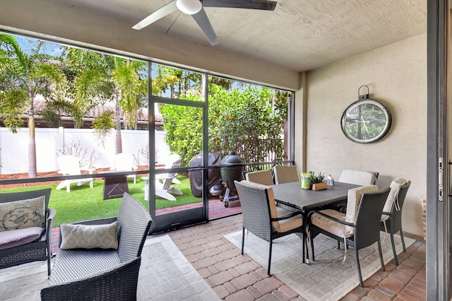 sunroom / solarium with a ceiling fan