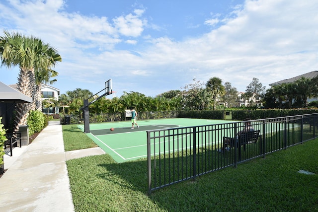 view of home's community featuring community basketball court, a lawn, and fence