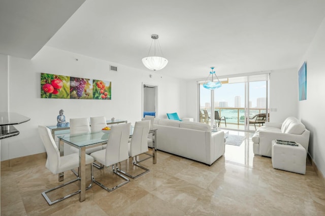 dining room featuring a city view, a wall of windows, and visible vents