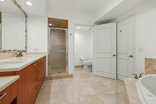 bathroom featuring a garden tub, toilet, a stall shower, a sink, and double vanity