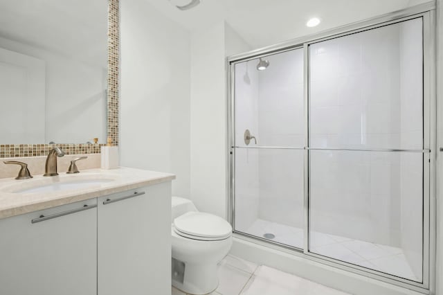 bathroom with vanity, a shower stall, tile patterned floors, toilet, and backsplash