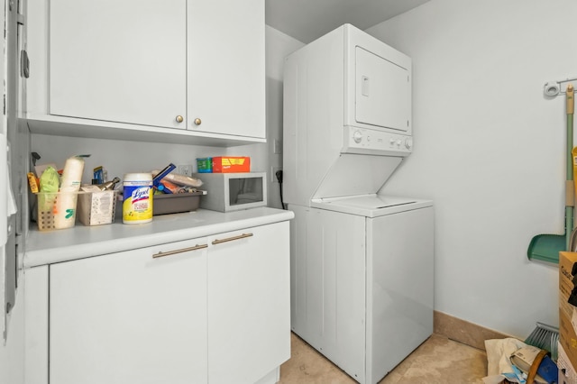 laundry area featuring cabinet space and stacked washer and clothes dryer