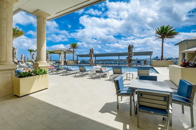 view of patio featuring a community pool and outdoor dining space