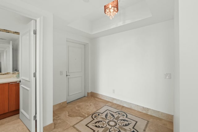 interior space featuring a raised ceiling and an inviting chandelier