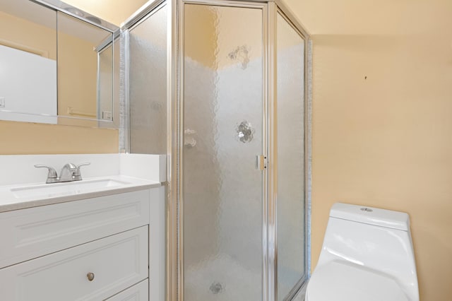 full bathroom with vanity, a shower stall, and toilet