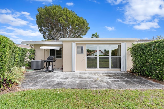 back of property with a patio area, central air condition unit, and stucco siding