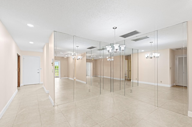 interior space featuring a notable chandelier, visible vents, and a textured ceiling