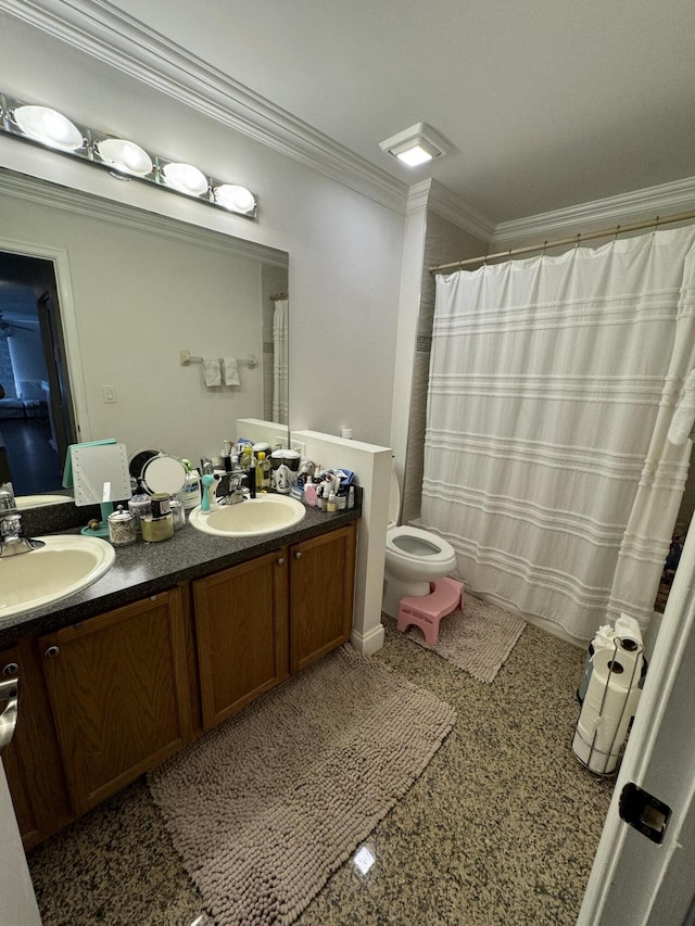 full bath with double vanity, ornamental molding, a sink, and toilet