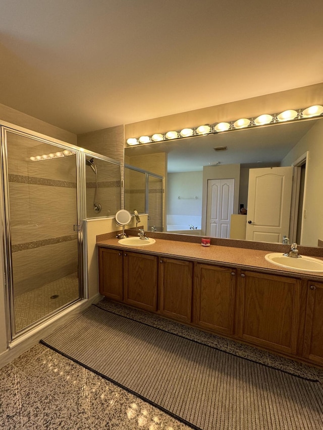 bathroom with tile patterned flooring, a sink, a shower stall, and double vanity