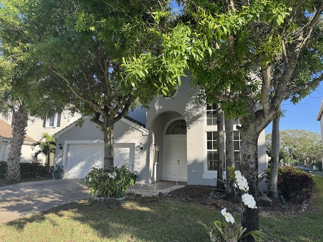 view of front of house featuring an attached garage, concrete driveway, and stucco siding