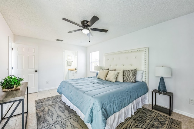 bedroom featuring a textured ceiling, light tile patterned floors, visible vents, and baseboards