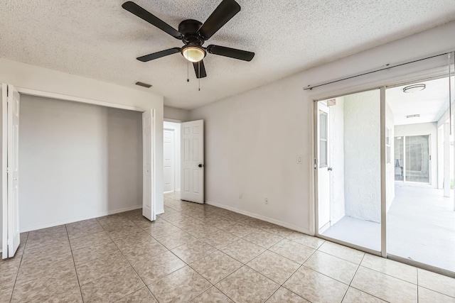 unfurnished bedroom with a textured ceiling, ceiling fan, a closet, and light tile patterned flooring