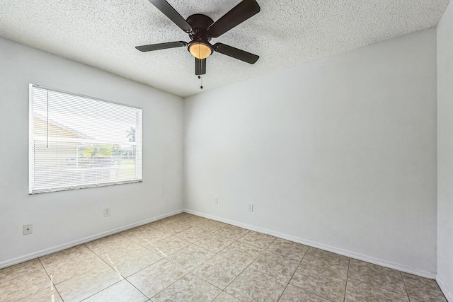 unfurnished room with light tile patterned floors, a ceiling fan, baseboards, and a textured ceiling