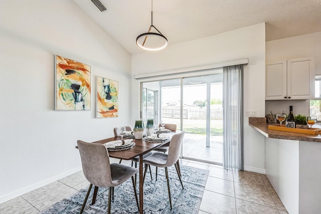 dining room with visible vents, vaulted ceiling, baseboards, and light tile patterned floors