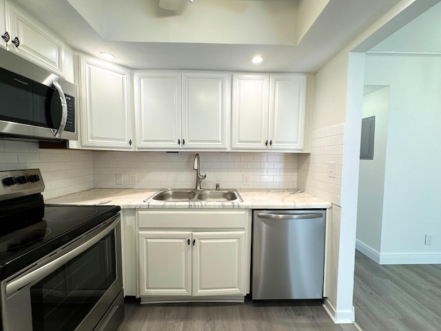 kitchen with tasteful backsplash, light wood-style flooring, appliances with stainless steel finishes, white cabinetry, and a sink