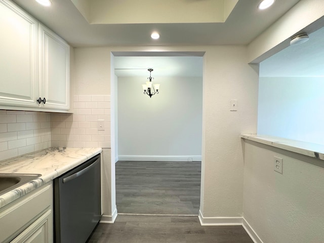 kitchen with baseboards, decorative backsplash, dark wood-style flooring, white cabinetry, and stainless steel dishwasher