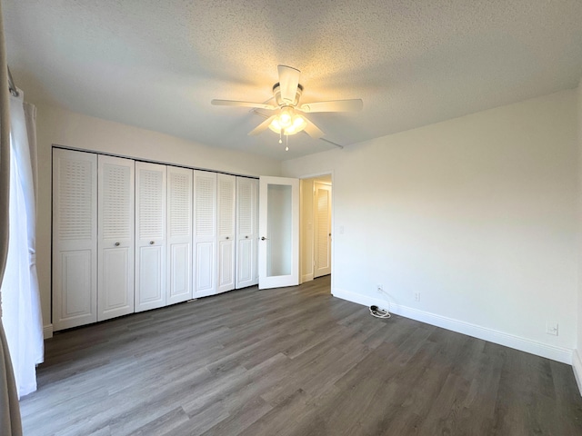 unfurnished bedroom featuring baseboards, ceiling fan, wood finished floors, a textured ceiling, and a closet