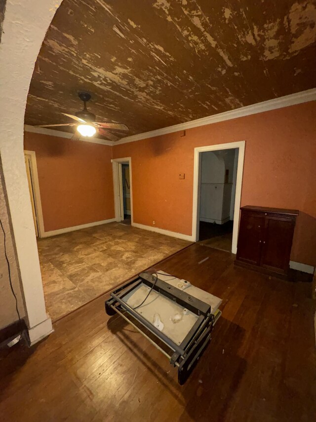 unfurnished living room featuring hardwood / wood-style flooring, baseboards, ornamental molding, and ceiling fan