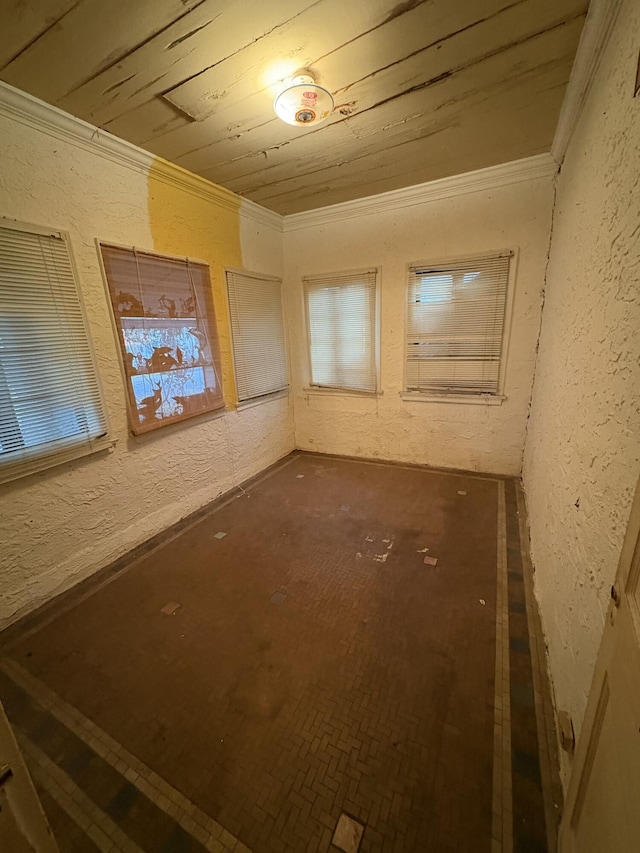 spare room with a textured wall, wooden ceiling, and crown molding