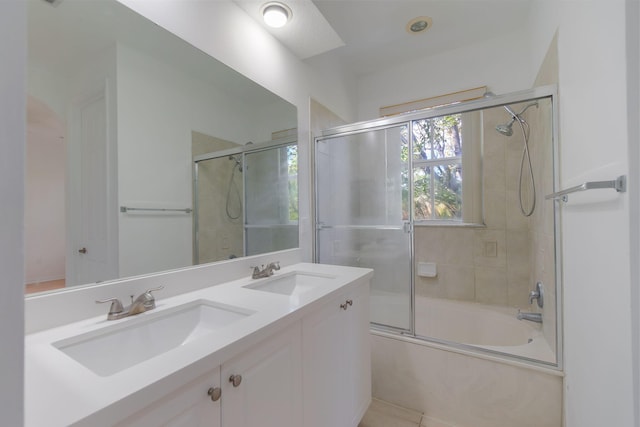 full bathroom featuring shower / bath combination with glass door, a sink, and double vanity