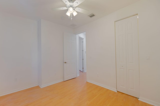 unfurnished bedroom with a closet, light wood-type flooring, visible vents, and baseboards