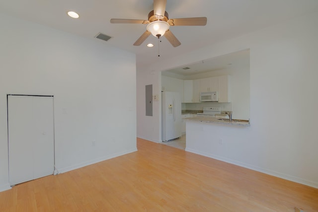 unfurnished living room featuring electric panel, visible vents, baseboards, light wood-style flooring, and recessed lighting