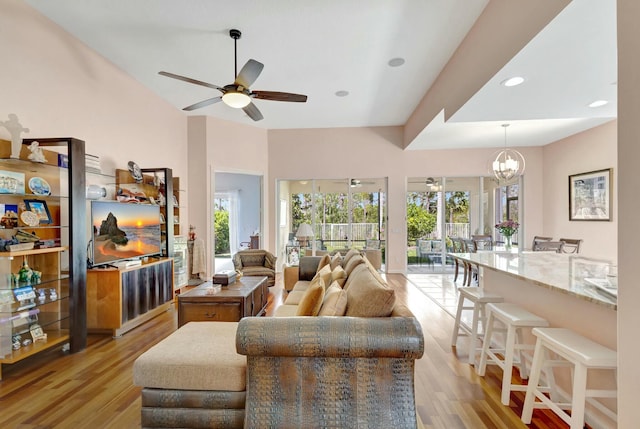 living area with recessed lighting, ceiling fan with notable chandelier, and light wood finished floors